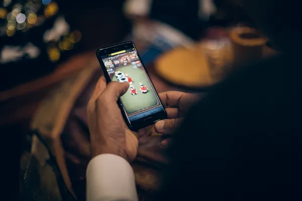 67777 Games — Discover modern slots and table adventures A man celebrating a winning moment on his laptop while gaming symbols float around him, capturing the excitement of 67777 games.